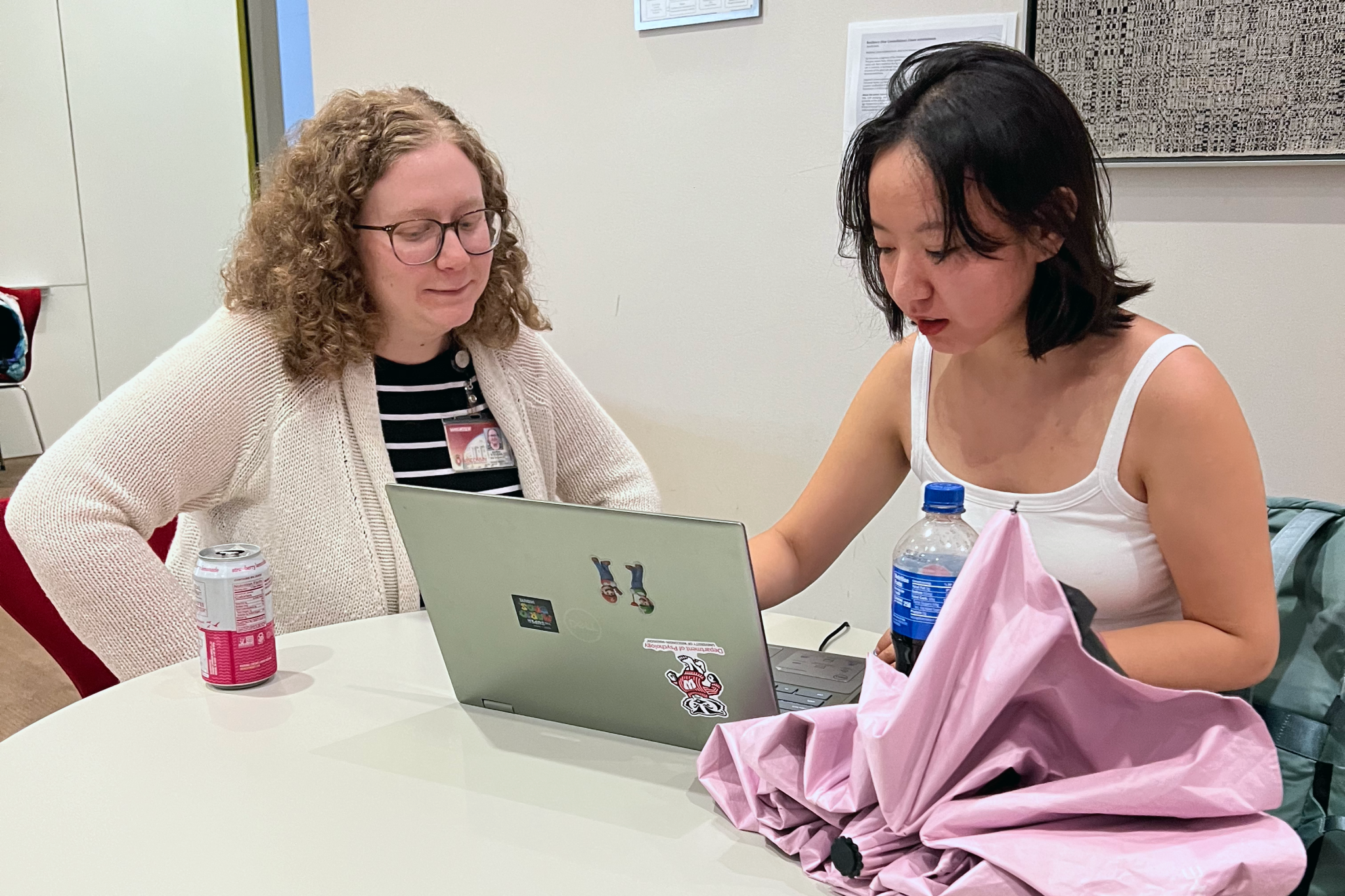 Two women looking at a laptop computer and talking.