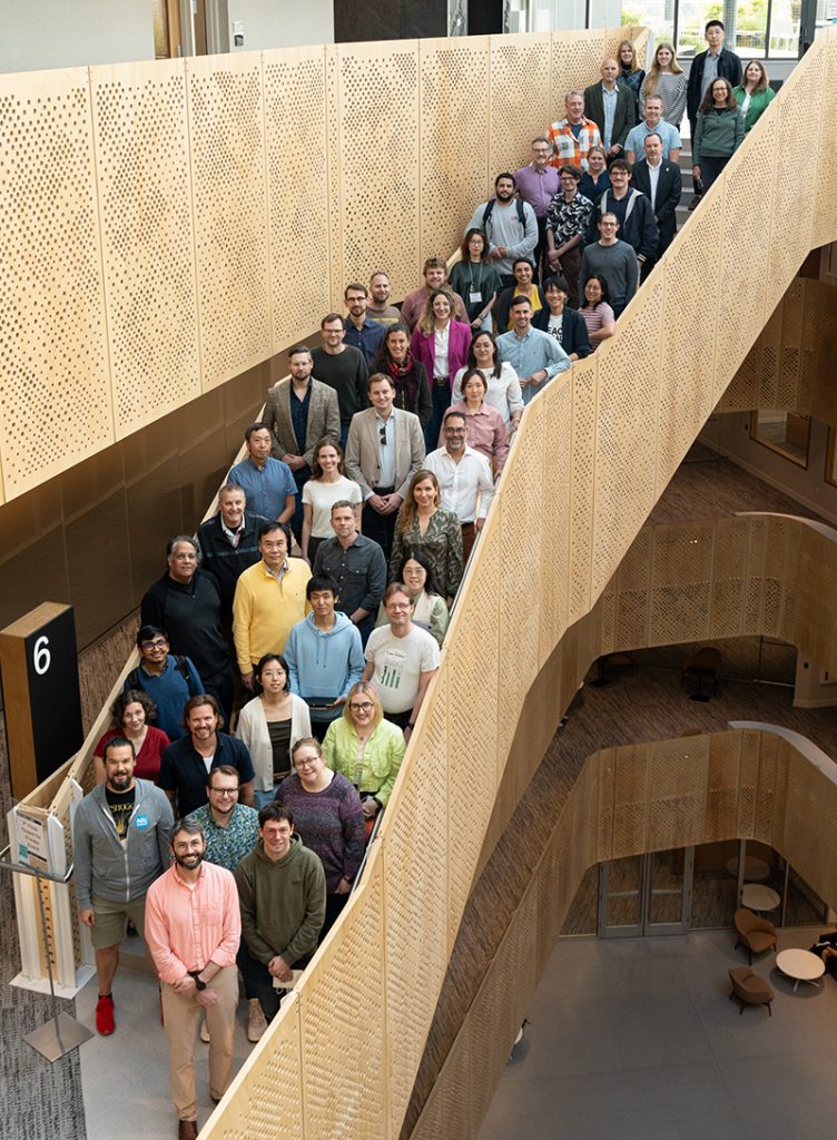 A group photo of researchers standing on a large staircase
