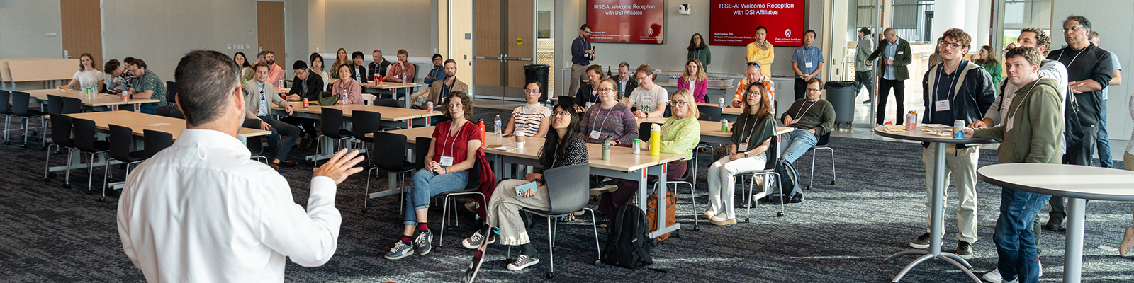 A large group of people listening to a presentation