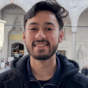 Photo of Haroon Quddus. He has dark hair and a beard and mustache, and he is wearing a dark sweatshirt.