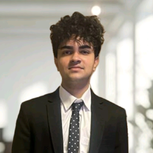 Photo of Mihir Narayan, He has dark hair and is wearing a dark suit jacket and a tie.